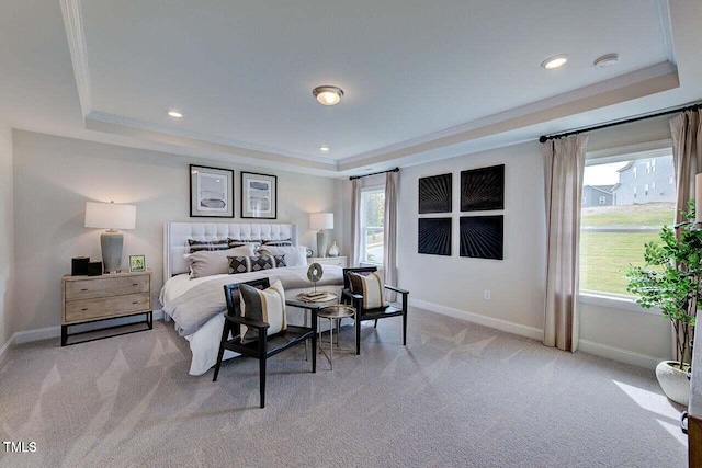 carpeted bedroom with a tray ceiling and crown molding