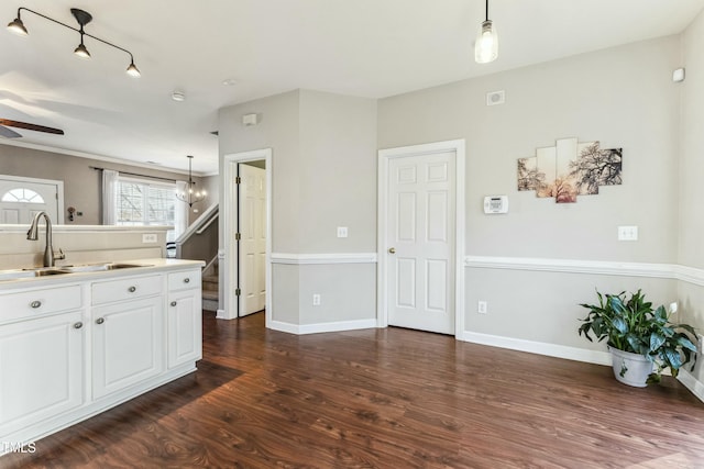 kitchen featuring ceiling fan, sink, hanging light fixtures, dark wood-type flooring, and white cabinets