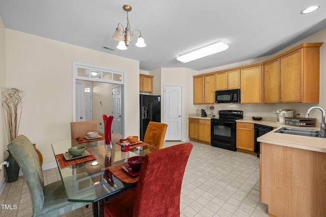 kitchen with sink, a notable chandelier, black appliances, and hanging light fixtures