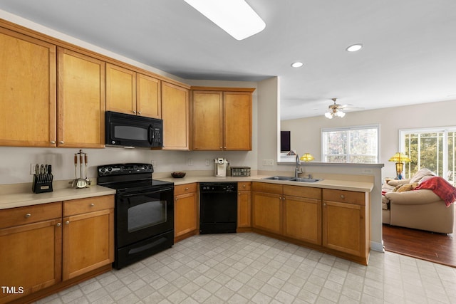 kitchen with sink, kitchen peninsula, ceiling fan, and black appliances