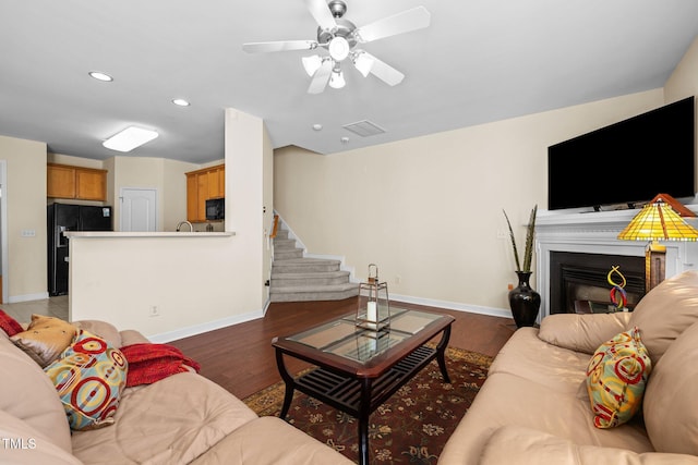 living room with dark wood-type flooring and ceiling fan