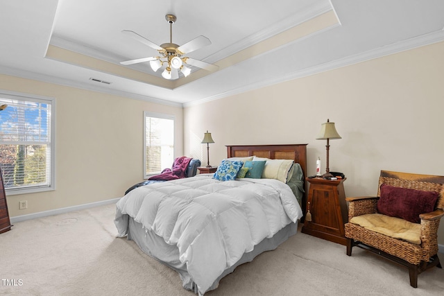 bedroom with crown molding, ceiling fan, a raised ceiling, and light carpet