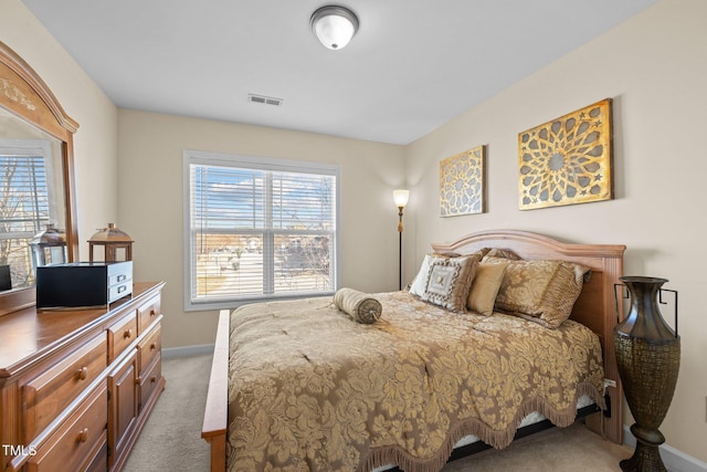 bedroom with multiple windows and light carpet