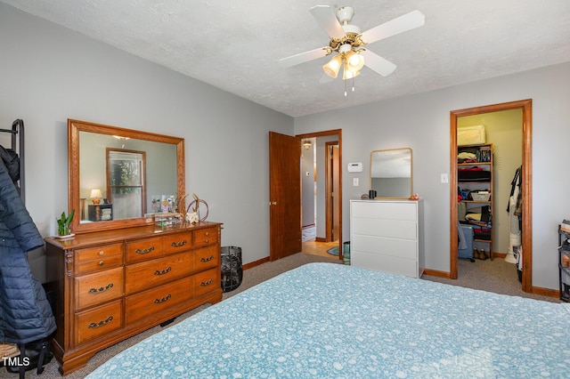 bedroom featuring a spacious closet, ceiling fan, a closet, and a textured ceiling