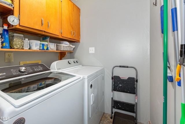 laundry area with separate washer and dryer and cabinets