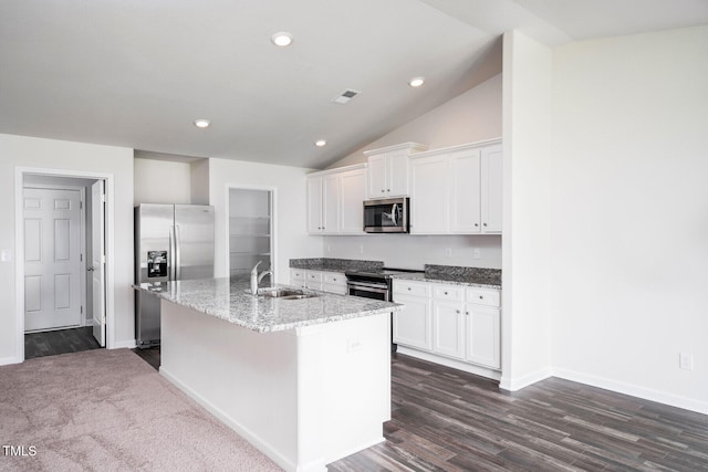 kitchen with vaulted ceiling, sink, a kitchen island with sink, appliances with stainless steel finishes, and white cabinets