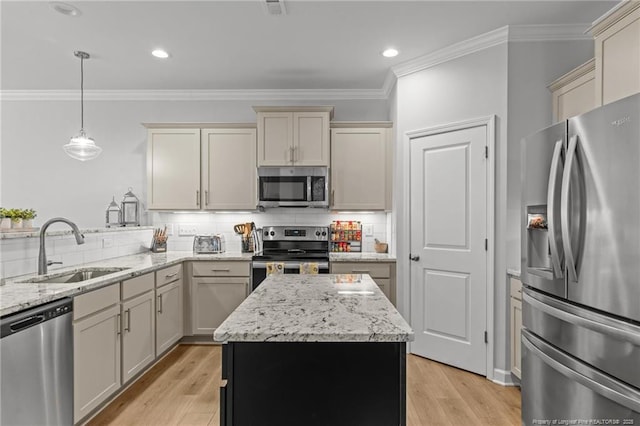 kitchen with decorative light fixtures, cream cabinetry, appliances with stainless steel finishes, and sink