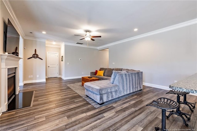 living room with crown molding, ceiling fan, and dark hardwood / wood-style floors