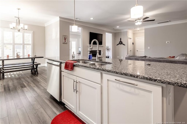 kitchen featuring sink, dark stone countertops, stainless steel dishwasher, dark hardwood / wood-style floors, and white cabinets