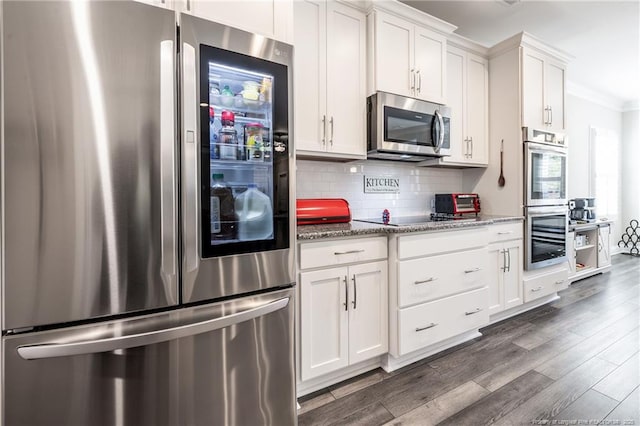 kitchen with white cabinetry, light stone counters, appliances with stainless steel finishes, dark hardwood / wood-style flooring, and backsplash