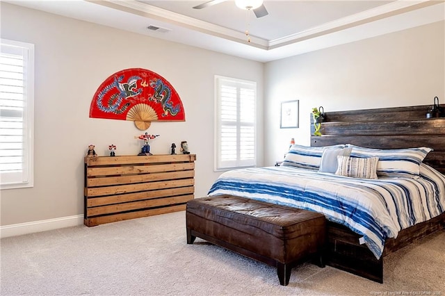 carpeted bedroom featuring crown molding, a tray ceiling, and ceiling fan