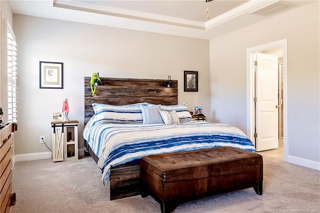 carpeted bedroom with ornamental molding and a raised ceiling