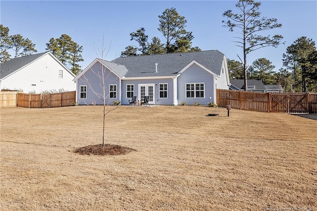 rear view of property with french doors and a lawn