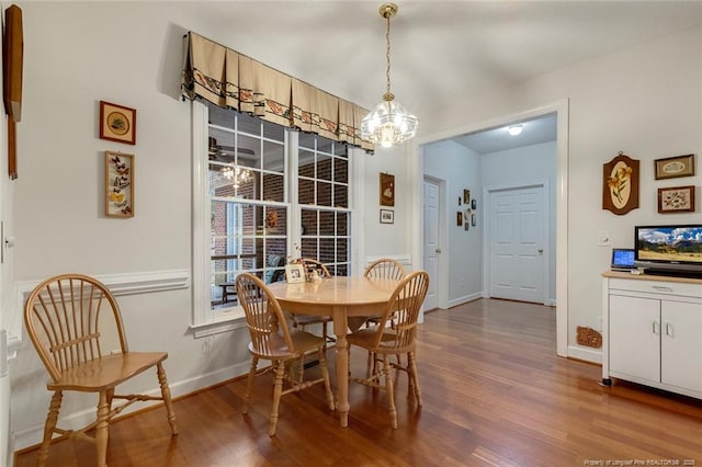 dining space featuring hardwood / wood-style flooring and a chandelier