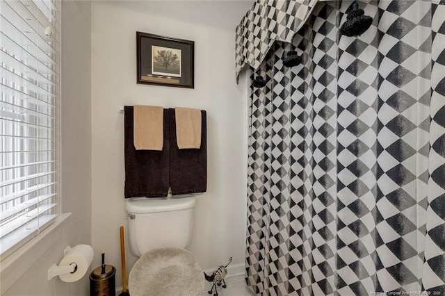 bathroom with toilet and a shower with curtain