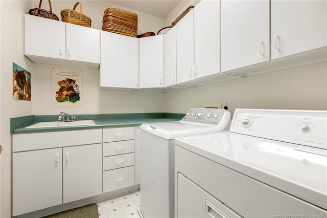 clothes washing area with washer and dryer, sink, and cabinets