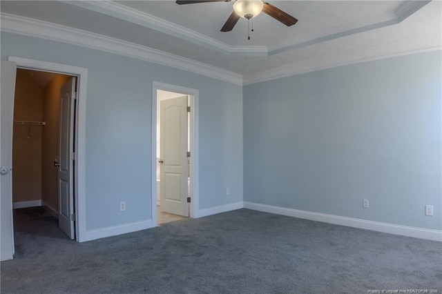 carpeted spare room with a raised ceiling, crown molding, and ceiling fan