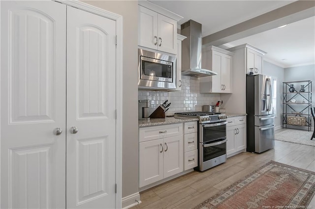 kitchen with stainless steel appliances, wall chimney exhaust hood, light hardwood / wood-style flooring, and white cabinets