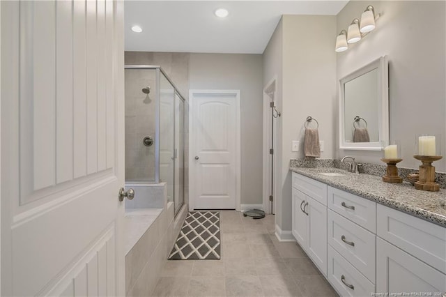 bathroom featuring a shower with shower door, vanity, and tile patterned floors