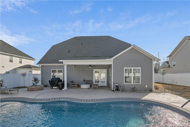 rear view of property featuring ceiling fan, a patio area, a fire pit, and a fenced in pool