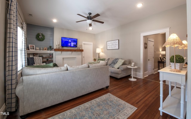 living room with ceiling fan and dark wood-type flooring