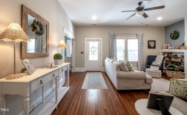 living room featuring ceiling fan and dark hardwood / wood-style flooring