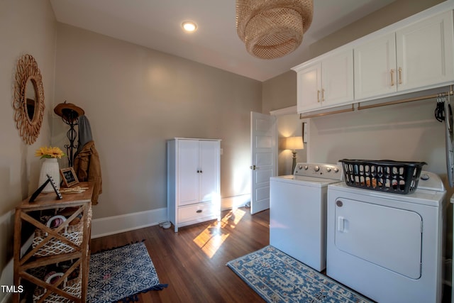 clothes washing area featuring washer and dryer, cabinets, and dark hardwood / wood-style floors