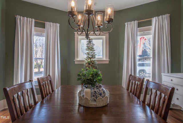 dining area featuring wood-type flooring and a notable chandelier