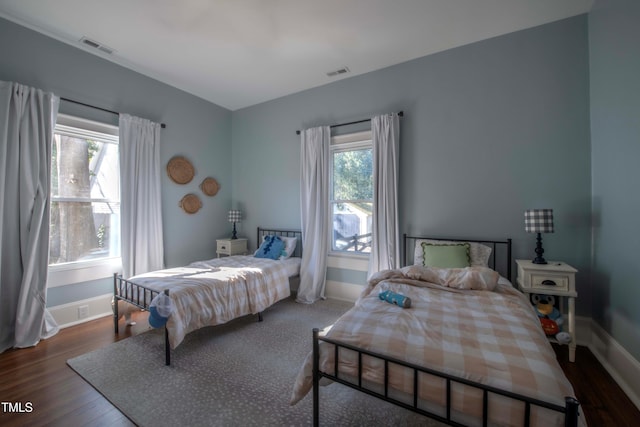 bedroom featuring dark hardwood / wood-style flooring and multiple windows