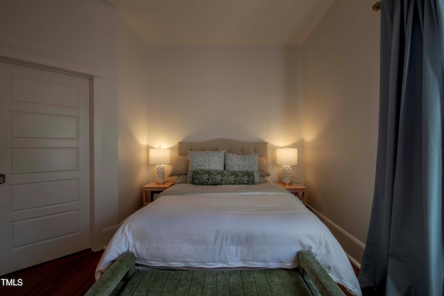 bedroom with dark hardwood / wood-style floors and lofted ceiling