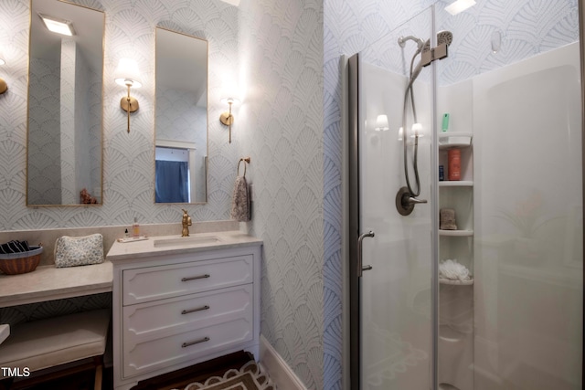 bathroom with a shower with shower door and vanity