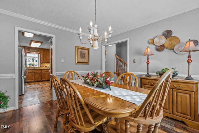 dining room featuring dark wood-type flooring, a notable chandelier, crown molding, and a textured ceiling