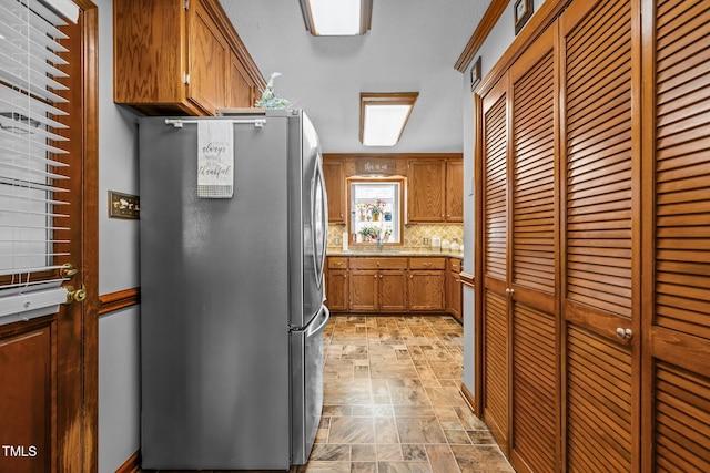 kitchen with backsplash and stainless steel fridge