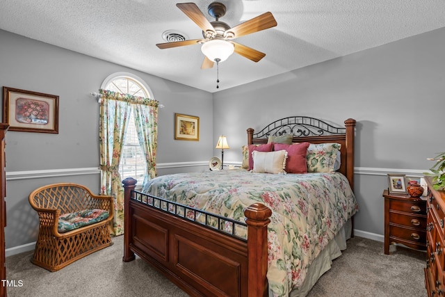 carpeted bedroom with ceiling fan and a textured ceiling