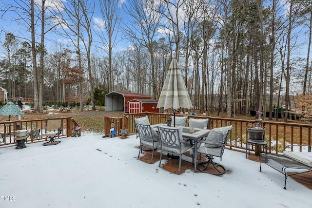 snow covered deck featuring a storage shed