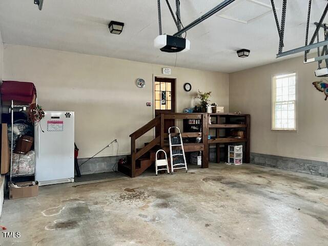 garage featuring a garage door opener and white fridge