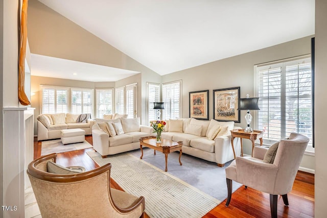 living room with high vaulted ceiling and light wood-type flooring