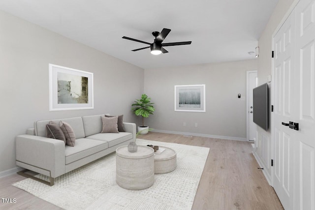 living room featuring ceiling fan and light hardwood / wood-style flooring