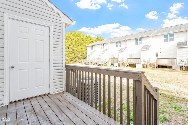 wooden terrace featuring central AC unit and a lawn