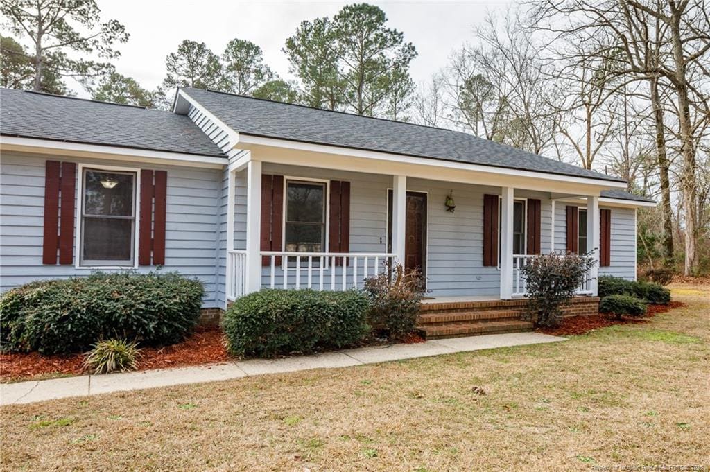 ranch-style home with a front lawn and a porch