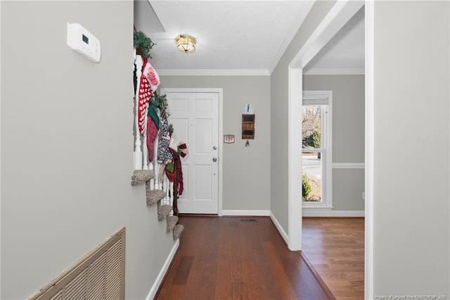 entryway with ornamental molding and dark hardwood / wood-style flooring