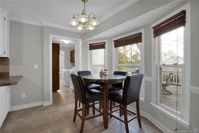 dining space with a notable chandelier, independent washer and dryer, and ornamental molding