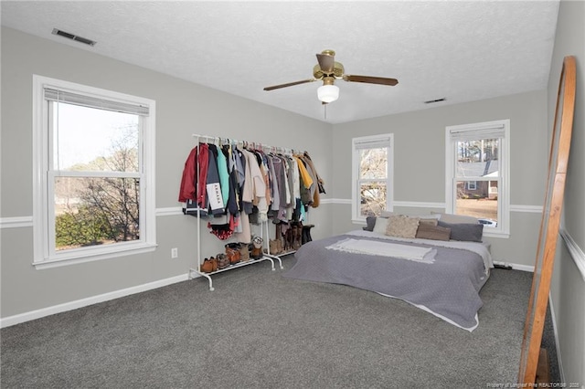 bedroom featuring ceiling fan, carpet, and a textured ceiling