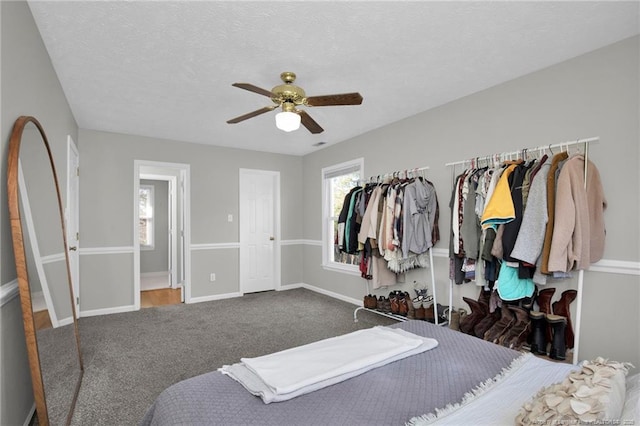 carpeted bedroom featuring a textured ceiling and ceiling fan