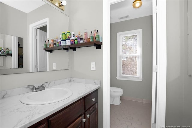 bathroom with toilet, tile patterned flooring, and vanity