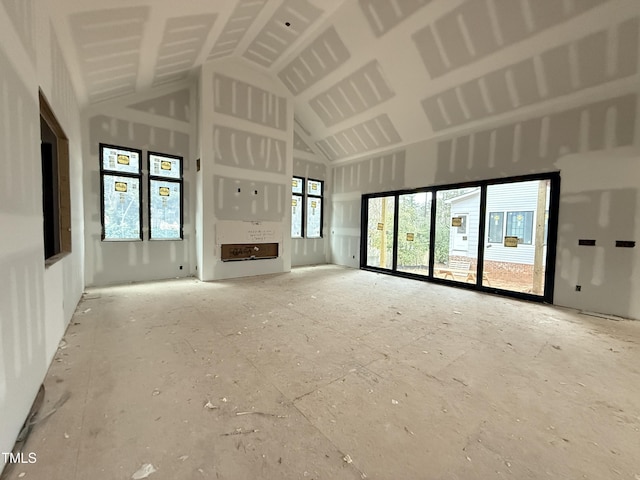 unfurnished living room featuring high vaulted ceiling