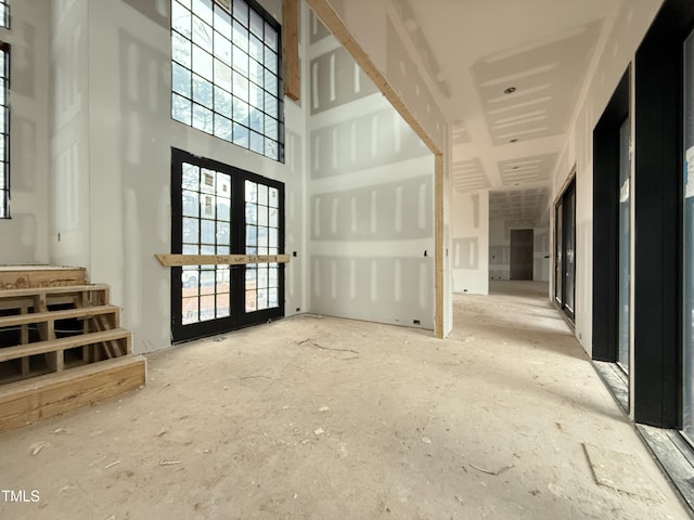 interior space featuring french doors and a towering ceiling