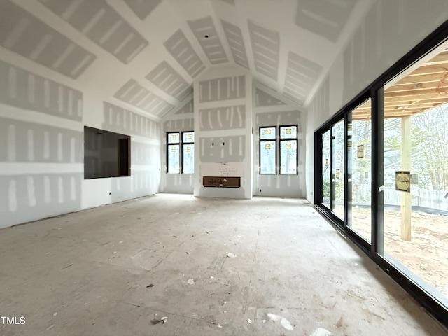 unfurnished living room featuring high vaulted ceiling