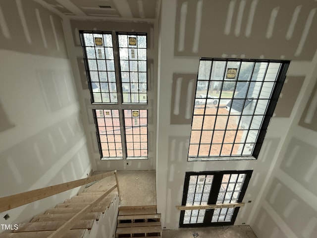 entryway with a towering ceiling and french doors