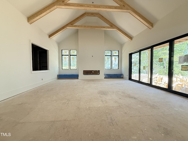 unfurnished living room featuring beamed ceiling, high vaulted ceiling, and baseboards